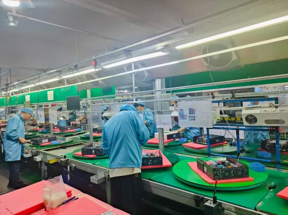 Solar inverter assembly workers on production line at Solarens